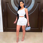 Woman in a white outfit standing in front of a decorative door.